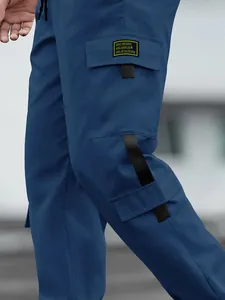 Detail of blue cargo pants with side pockets and high-street decorative patch