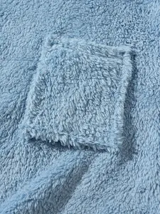 Close-up detail of soft blue plush fleece fabric showing a square pocket on a sweatshirt.