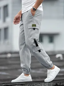 Detail view of light grey cargo joggers featuring side pockets and black strap accents