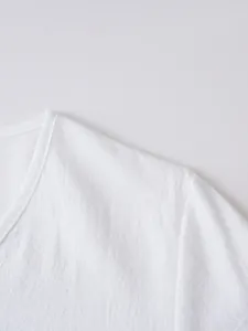 Detailed close-up showing the breathable linen texture and stitching of white V-neck shirt