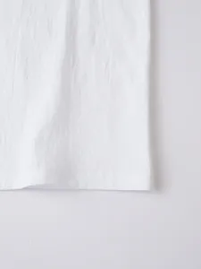 Close-up of white breathable linen fabric texture on casual long sleeve shirt hem