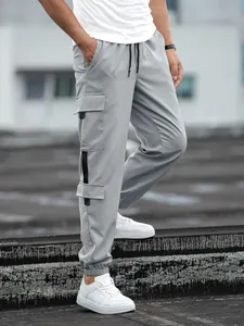 Detailed view of grey men's cargo joggers featuring stylish side pockets and techwear straps
