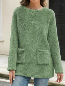 Close-up detail of a soft sage green fleece sweatshirt featuring fuzzy texture and front pockets