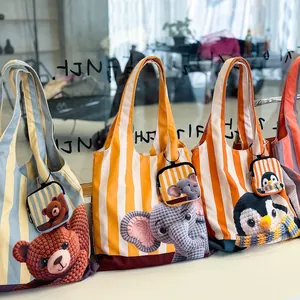 Vue détaillée de sacs fourre-tout rayés avec motifs animaux et pochettes assorties.