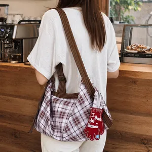 Sac cabas rétro en toile à carreaux avec breloque gant rouge dans un décor de café