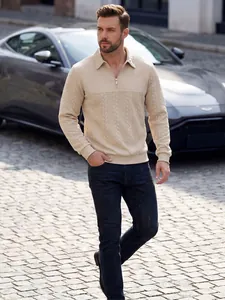Nahaufnahme eines beigen Herren-Zopfstrickpullovers mit Reißverschluss im Freien.