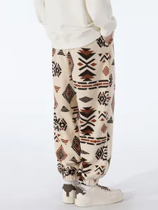Back view of men's tribal pattern fleece joggers with elastic cuffs for winter warmth.