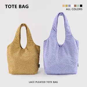 Detailed view of textured pleated tote bags in mustard and lilac for daily commuting.