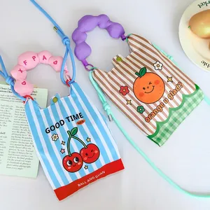 Detail view of two cartoon crossbody phone bags with cherry and orange prints.