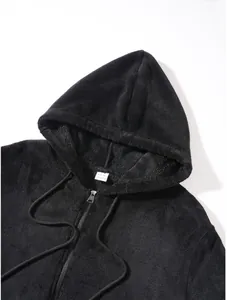 Close-up detail of black fleece hoodie showing soft plush texture and metal zip closure