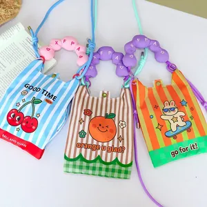 Macro view of three cartoon mini crossbody bags with puffy handles and colorful stripes.
