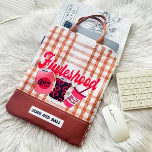 Close-up of checkered laptop sleeve featuring vibrant graffiti soda can prints and text