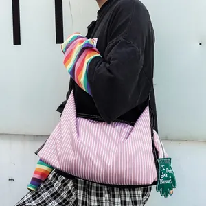 Détail du sac cabas à rayures roses avec un accessoire original en forme de gant vert