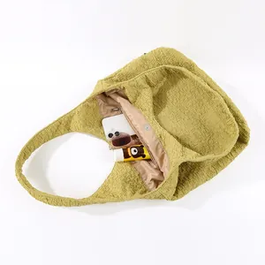 Interior detail of a yellow crinkled texture tote bag showing pockets and lining