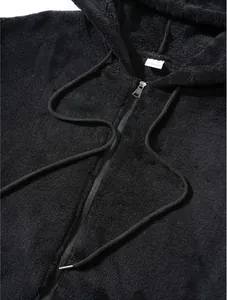 Close-up detail of a black plush fleece zip-up hoodie showing texture and zipper