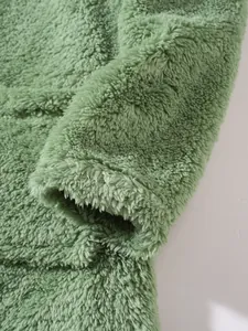 Close-up macro view of soft green plush fleece fabric texture on this stylish sweatshirt