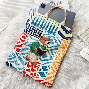 Detail of graffiti print laptop sleeve with cute bear embroidery on plush rug