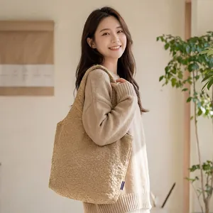 Young woman styling a large khaki textured fleece tote bag for a versatile commute look
