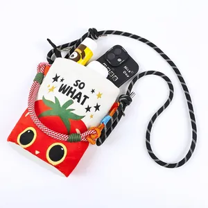 Detailed view of cartoon tomato print bucket bag with phone and essentials inside