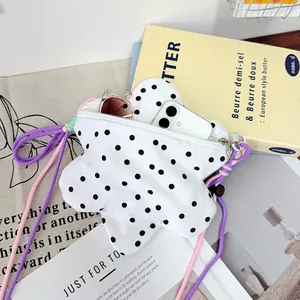 Trendy star-shaped polka dot crossbody bag showing capacity for phone and glasses.