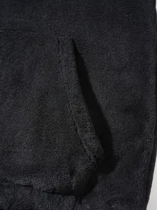 Macro detail showing the soft black fleece fabric and pocket stitching of the hoodie