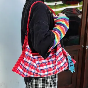 Détail d'un sac cabas en toile à carreaux rouges avec un porte-clés gant bleu créatif.