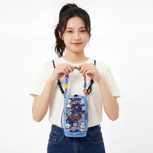 Detailed shot of a cute blue crossbody phone bag with cartoon patches held by a model