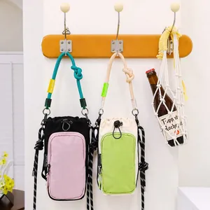 Japanese style dopamine crossbody phone bags hanging on wall hooks with casual props.
