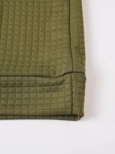 Vista macro detallada de la textura de tela tipo gofre verde oliva en una sudadera