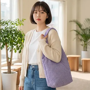 Close-up of a stylish purple popcorn textured tote bag carried by a model in lifestyle setting