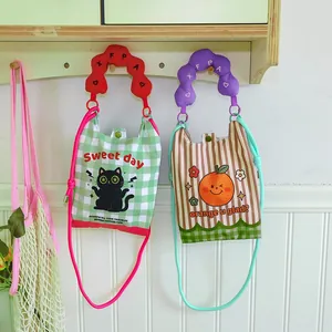 Detail view of two creative cartoon mini crossbody bags featuring cat and orange patterns