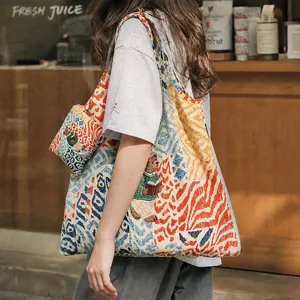 Detail of a colorful painted tote bag with bear embroidery and matching mini pouch