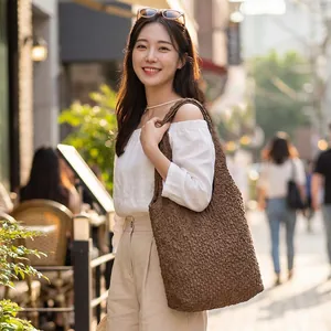 Large coffee brown bubble textured tote bag shown on a model in a casual street setting