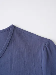 Close-up detail of breathable linen fabric and V-neck on a men's casual long-sleeve top.