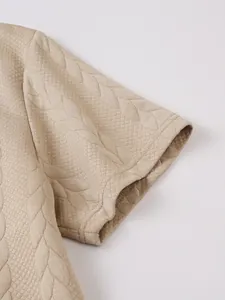 Detailweergave van de kaki jacquardstof op een casual herenshirt met korte mouwen.