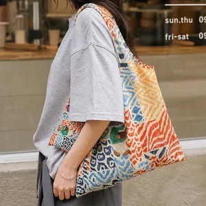 Lifestyle detail of a colorful patterned tote bag with bear motif and matching pouch