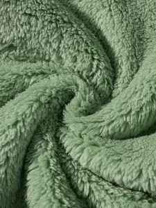 Close-up detail of soft sage green plush fleece fabric texture for sweatshirt
