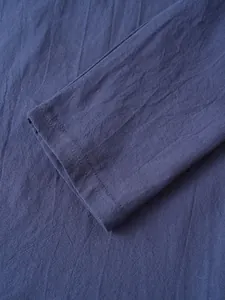 Detailed macro view of navy blue linen shirt cuff showing breathable fabric texture