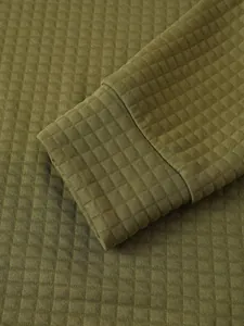 Primer plano de la textura de rejilla verde oliva en el puño de una sudadera de hombre