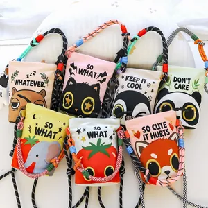 Detailed view of multiple cartoon print mini crossbody bucket bags with colorful braided cord straps