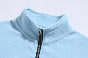 Detalle del cuello alto y la cremallera de una sudadera de forro polar azul claro