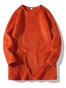Detail shot of orange fuzzy crewneck sweatshirt with front pockets and soft texture