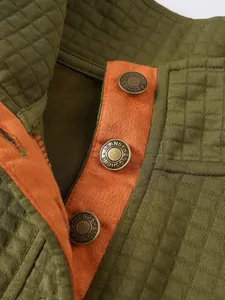 Primer plano de sudadera acolchada de rejilla con cuello alto y botones grabados