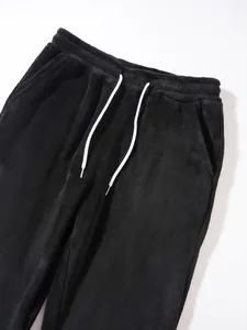 Close-up of black fleece joggers featuring an elastic waistband and white drawstrings