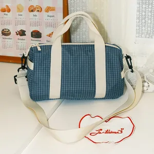Vista dettagliata della borsa bowling a scacchi blu con tracolla crema