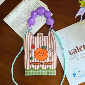 Detailed shot of a creative cartoon orange mini crossbody phone bag on a table