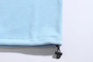 Detailansicht eines blauen Fleece-Sweatshirts mit verstellbarem Kordelzug am Saum