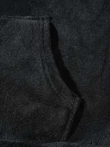 Close-up of black plush fleece fabric texture and pocket stitching detail.