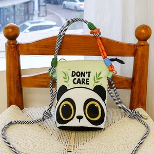 Close-up of a cartoon panda crossbody bucket bag with colorful braided rope strap