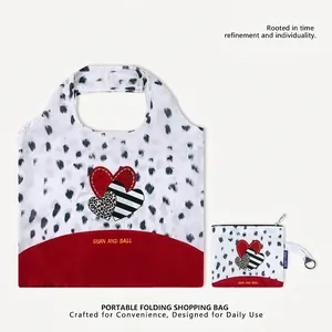 Detail view of portable folding shopping bag with heart pattern and matching pouch